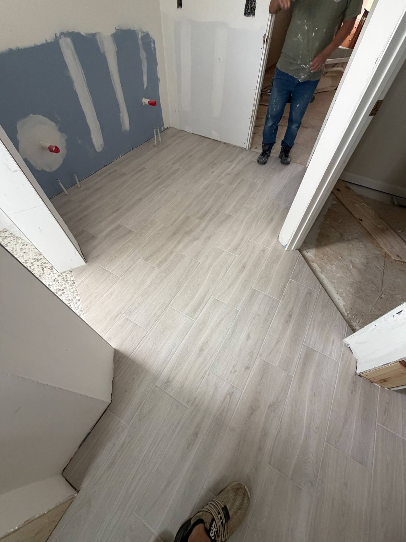 Wood-look plank tile flooring going in — durable and warm underfoot.