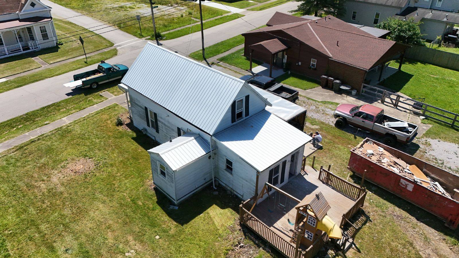 Tearing off the old roof and installing fresh standing-seam metal panels.